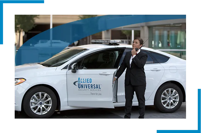 Security professional in a suite holding the door of a car