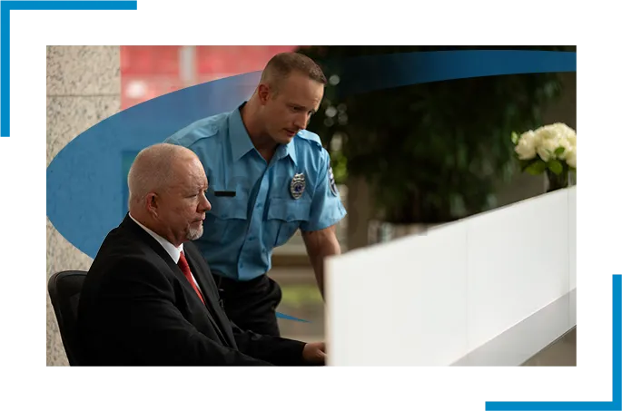 two security guards in the reception looking at a computer